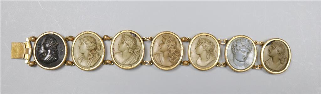 A Victorian gilt metal and lava bracelet, set with seven oval panels carved with busts of ladies and gentleman, 17.2cm.